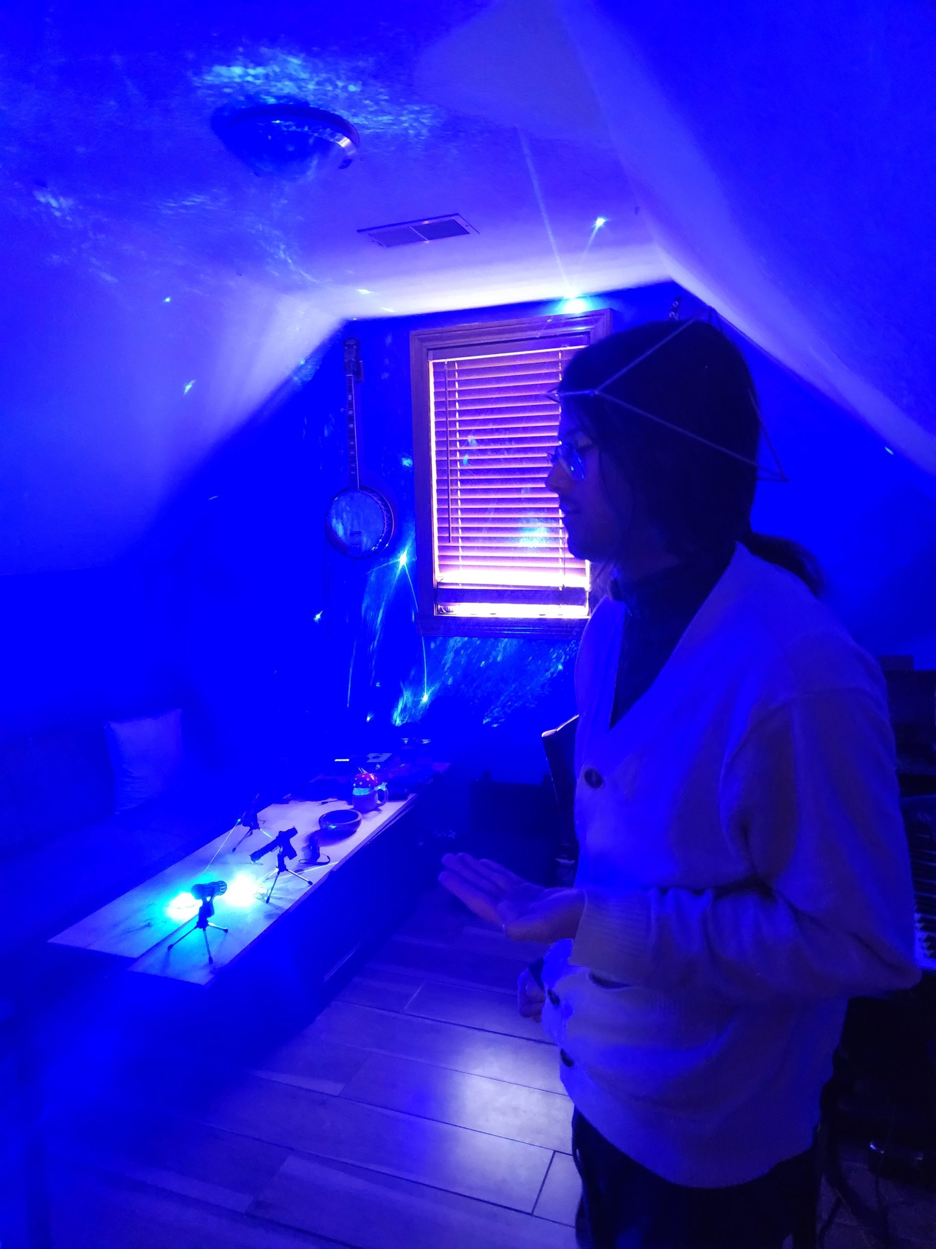 A person standing in a room filled with blue coherent light during a session