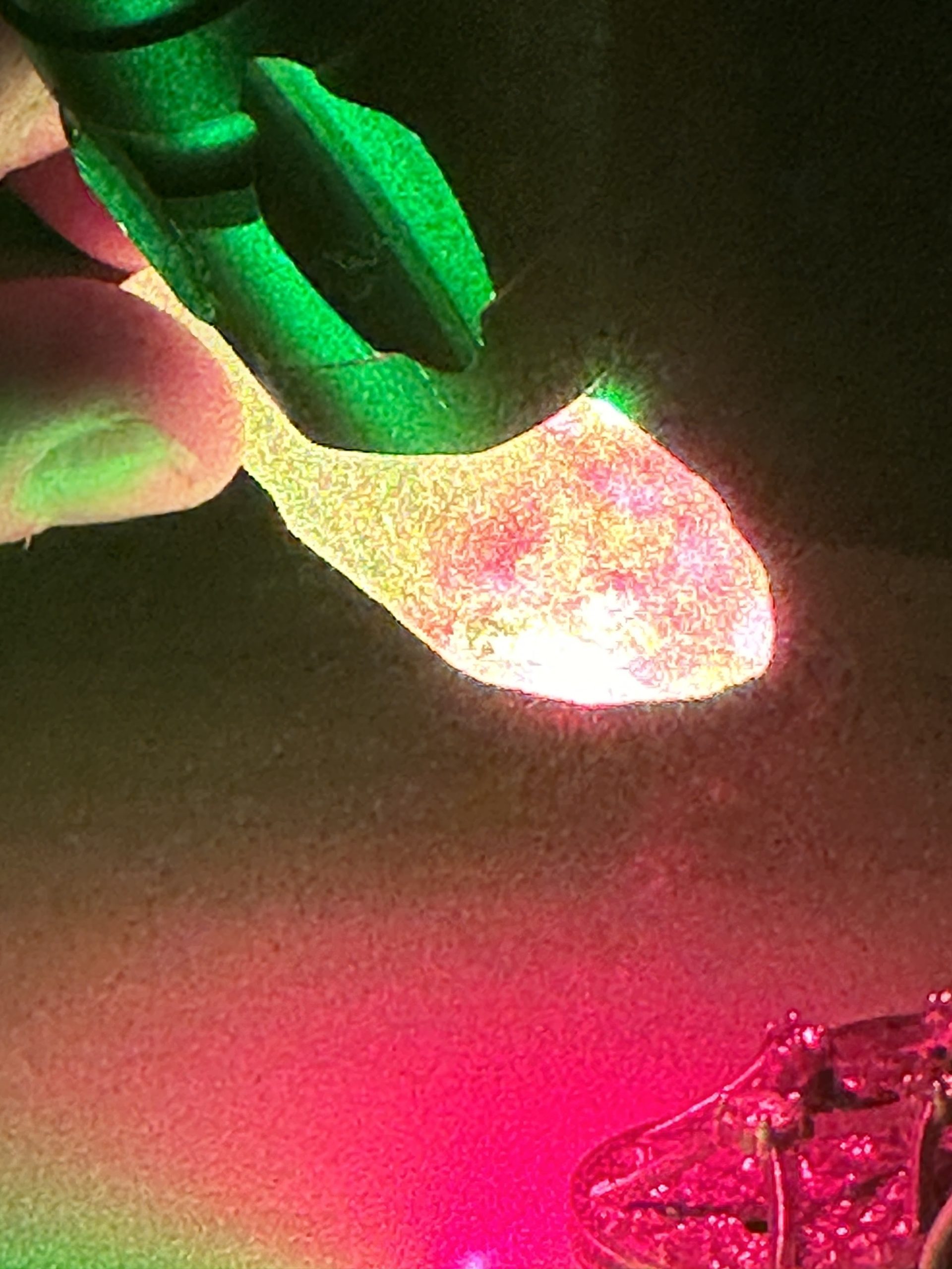 Green laser light passing through a crystal held in the hand