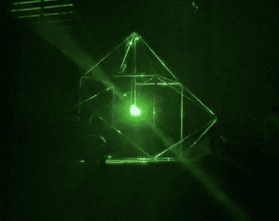 Green laser passing through a pyramid and crystal