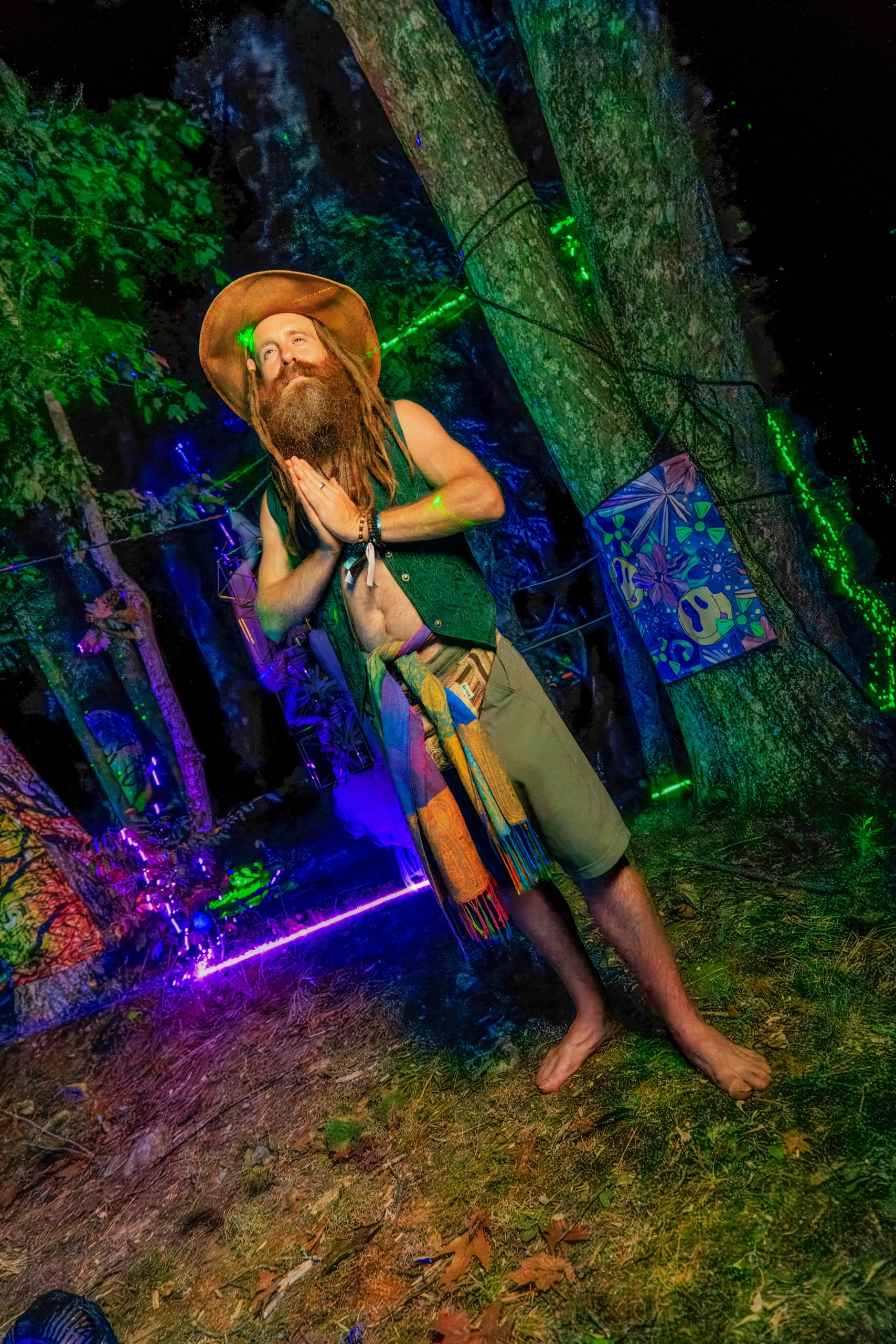 Logi Parkerson standing in the forest installation among laser light