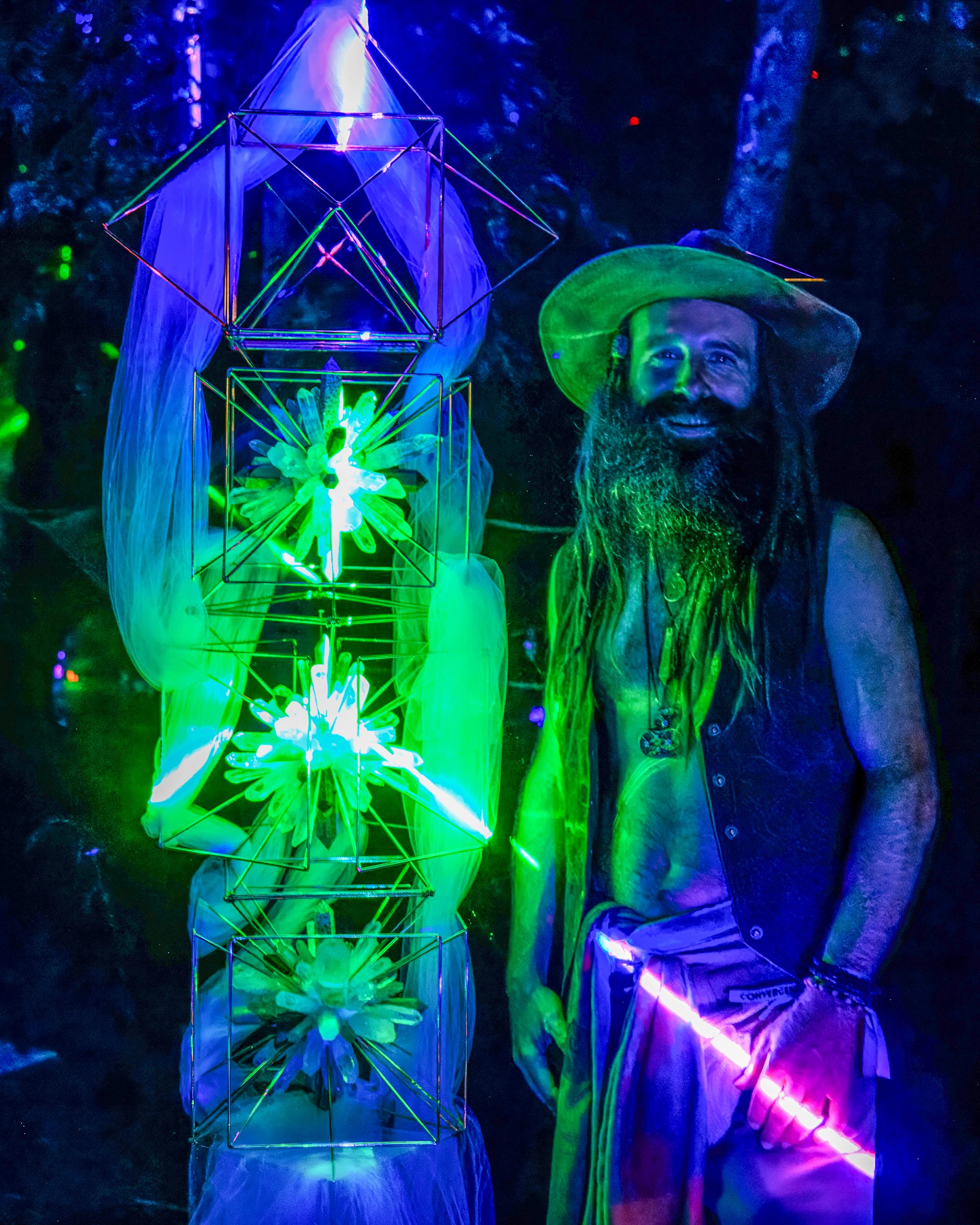 Logi Parkerson standing beside the illuminated crystal lattice tower