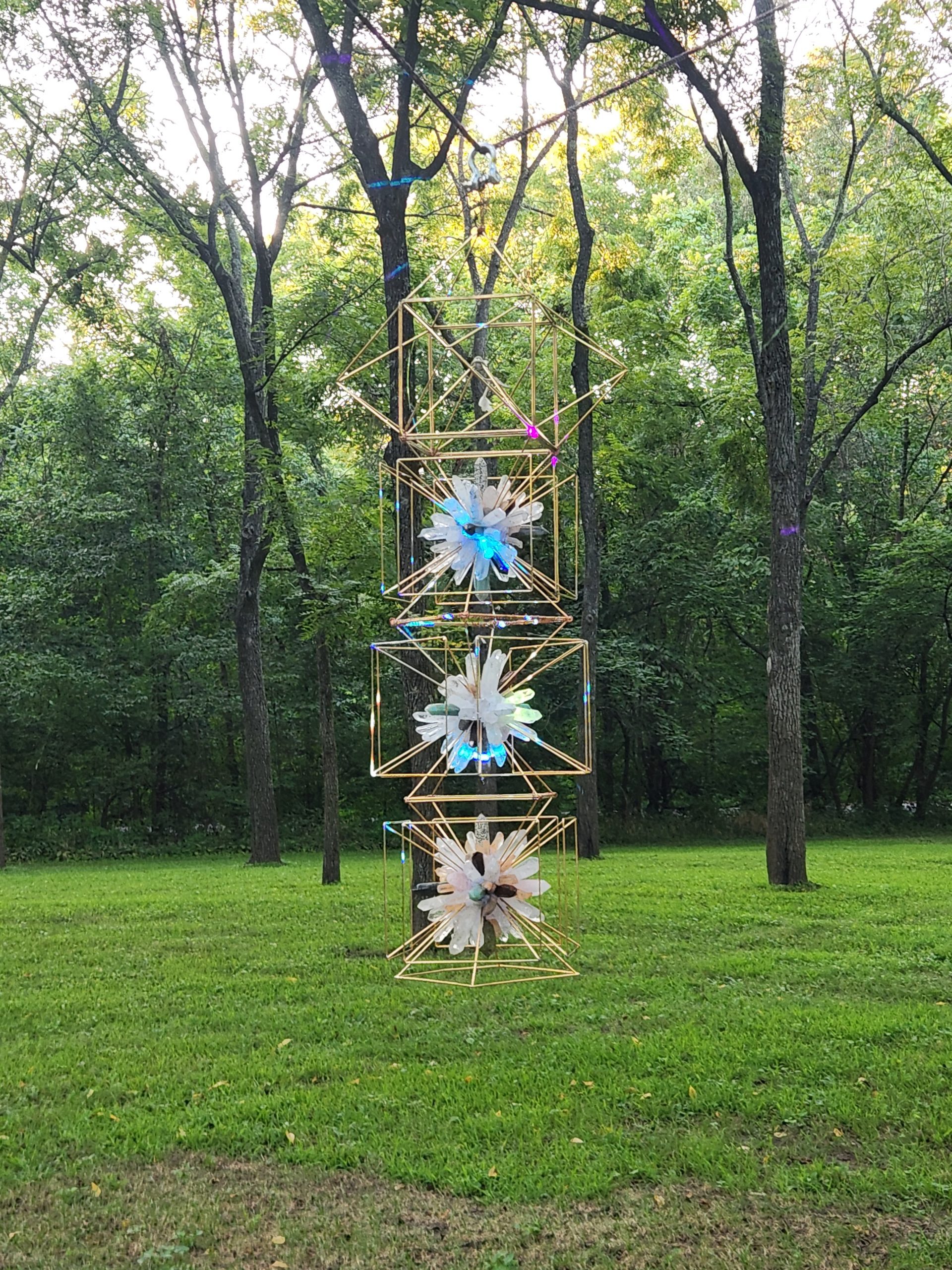 Portal of Light crystal and metal lattice tower in a forest clearing by daylight